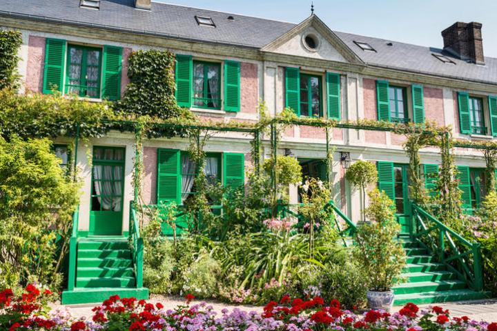 a close up of a flower garden in front of a house