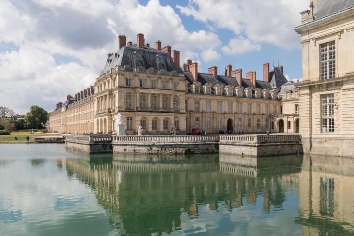 a castle with water in front of a building